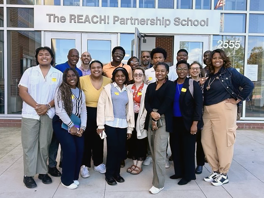 Students and faculty pose outside the REACH! Partnership School.