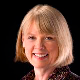 A woman smiling in a black background