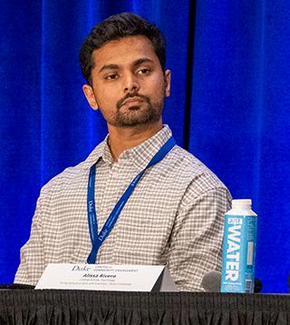 Photo of Dhaval Potdar serving on a panel at a meeting in front of Duke Blue backdrop.